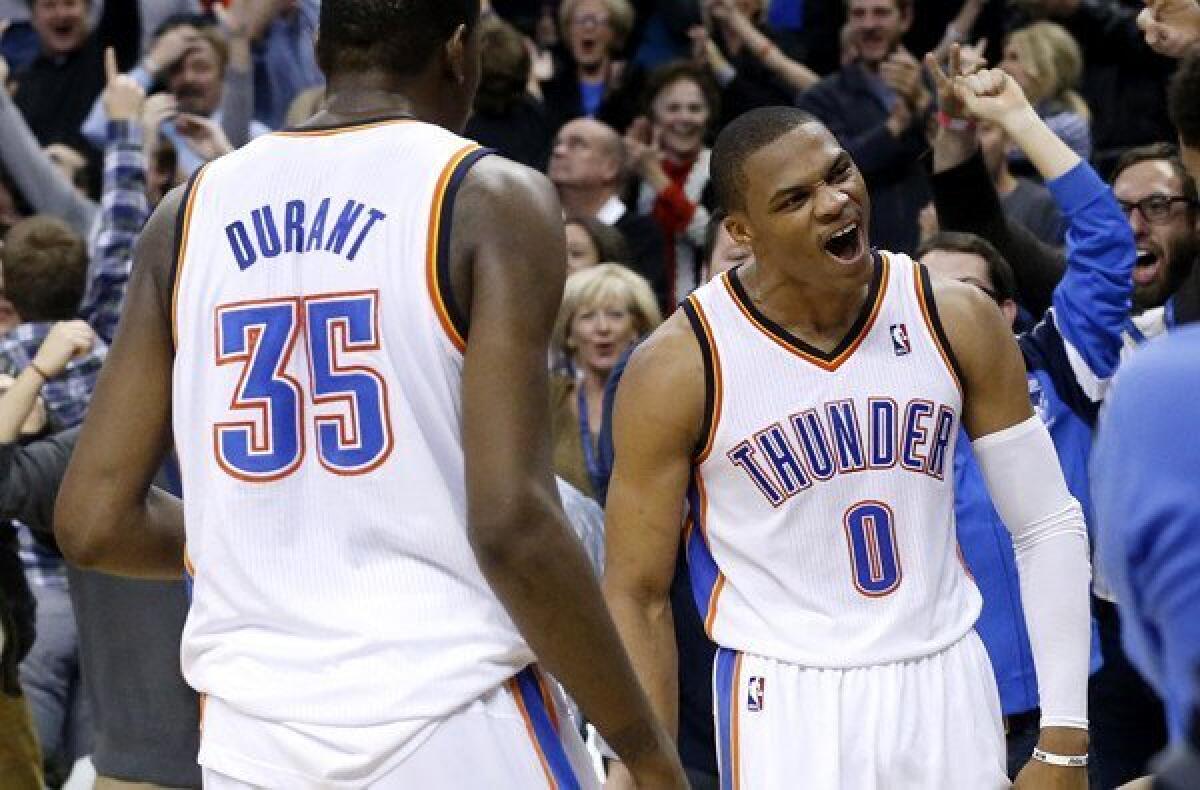Thunder point guard Russell Westbrook and forward Kevin Durant celebrate after Westbrook made a last-second three-point basket in the final second of overtime to defeat the Warriors in Oklahoma City.