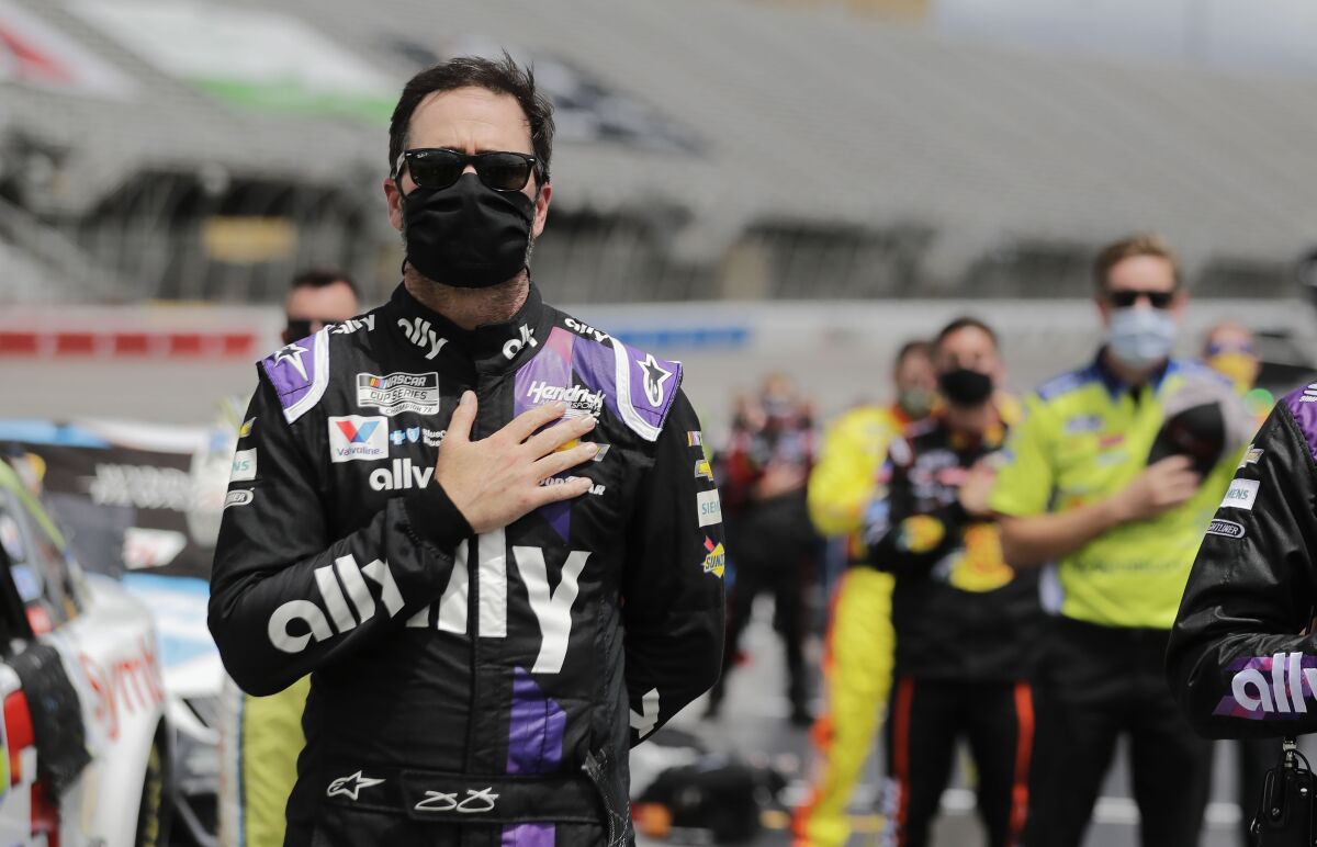 Jimmie Johnson stands with crew members during the national anthem Sunday at Atlanta Motor Speedway.