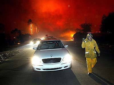 Residents of North Claremont flee as oncoming flames jump over Pomello Drive early Sunday morning.