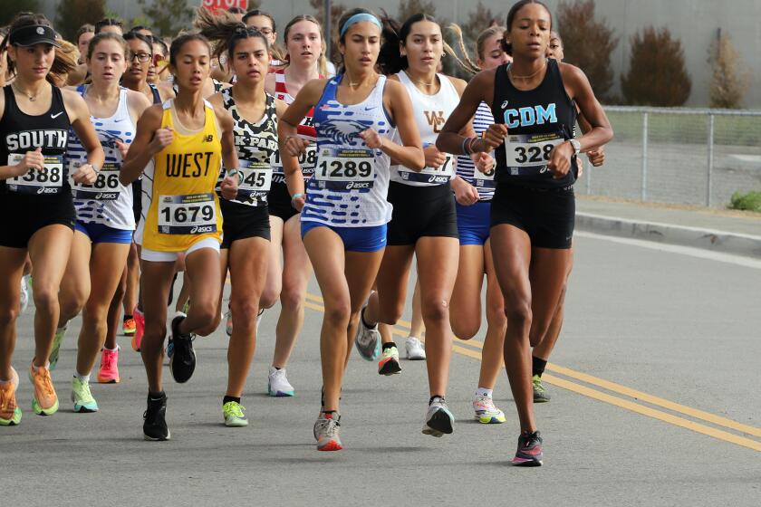 CdM's Melissa Djomby Enyawe, right, (328) leads the CIFSS Division 3 girls' cross-country race,
