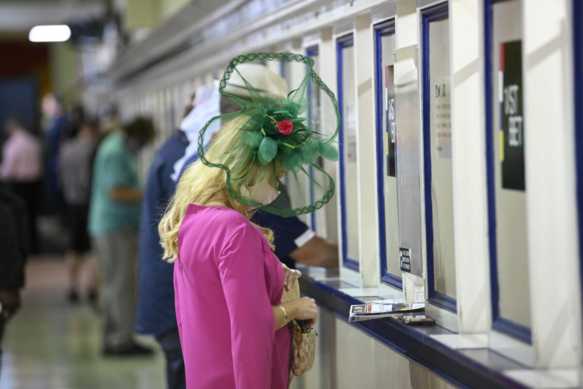A woman places a bet at Pimlico Race Course before the Preakness Stakes on Saturday.