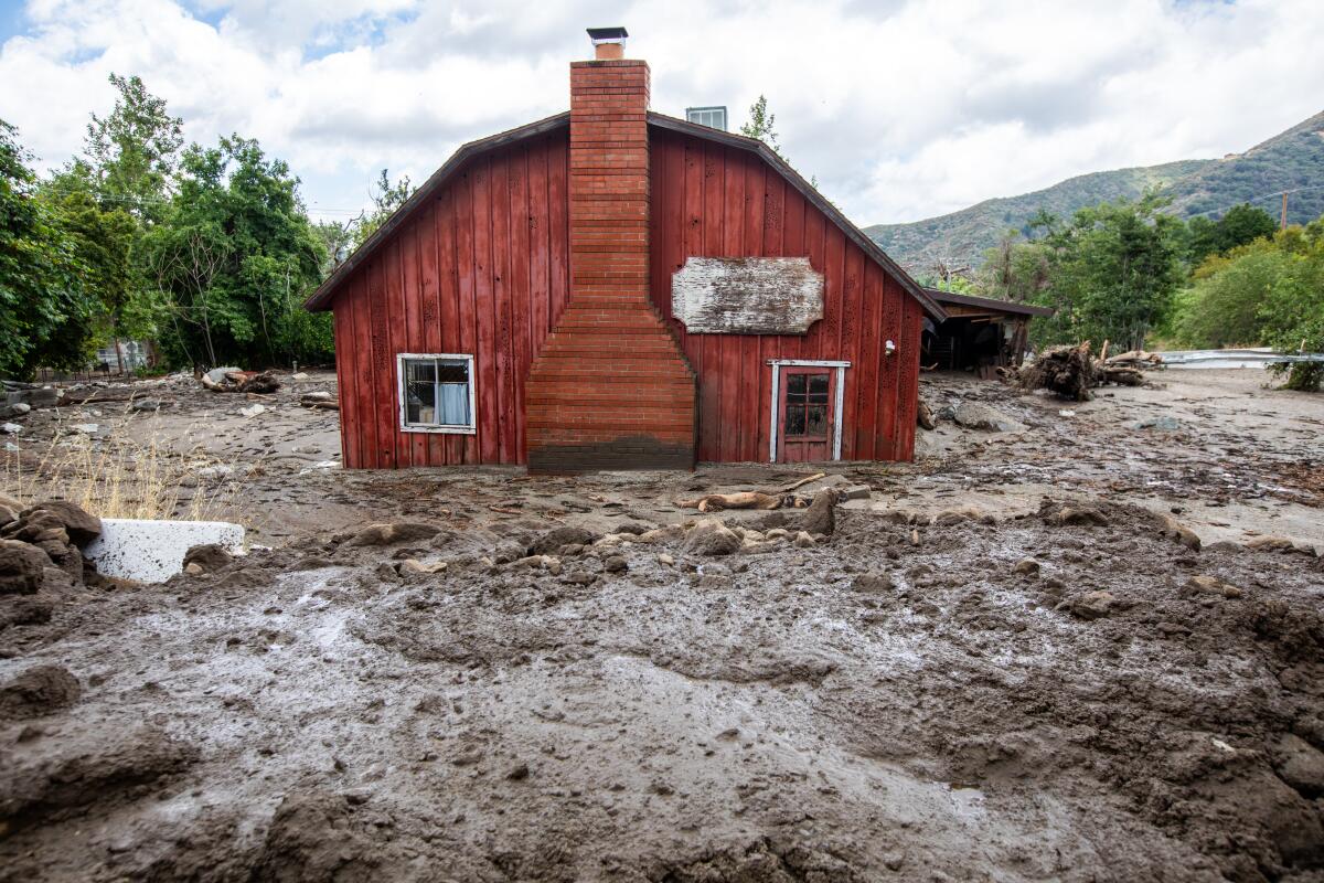 A red house in Oak Glen, Calif., is encased in deep mud after Tropical Storm Hilary.