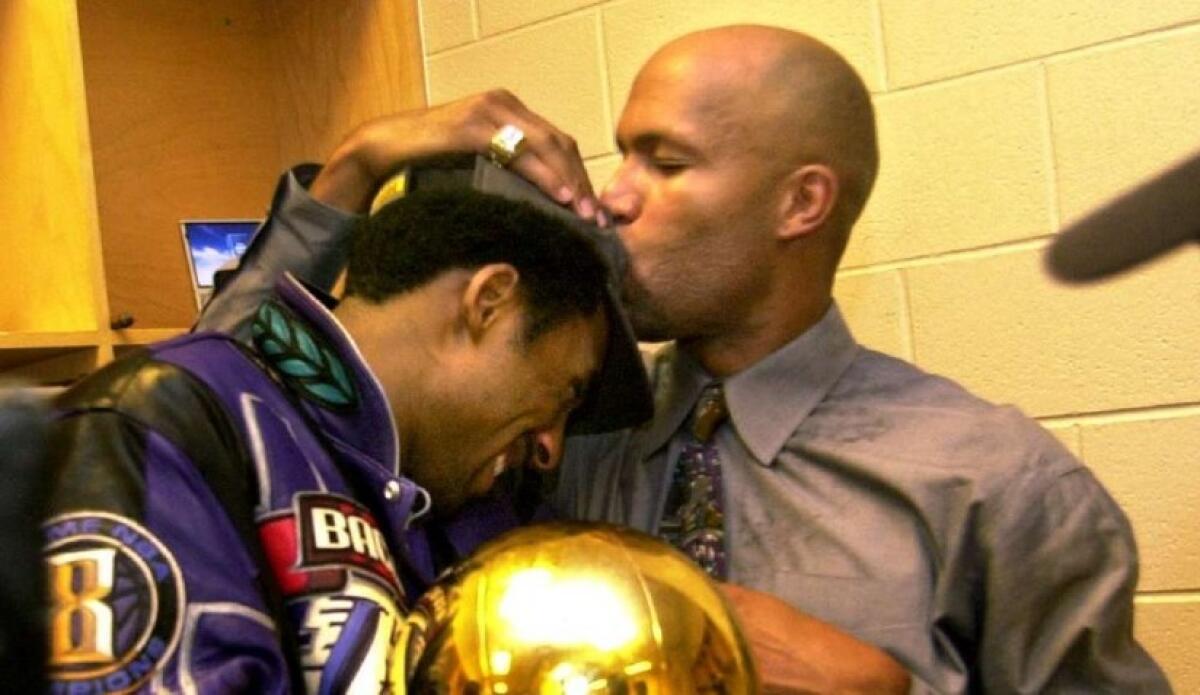 Kobe Bryant gets a kiss on the head from teammate Ron Harper after defeating the 76ers in Game 5 of the NBA Finals on June 13, 2001.