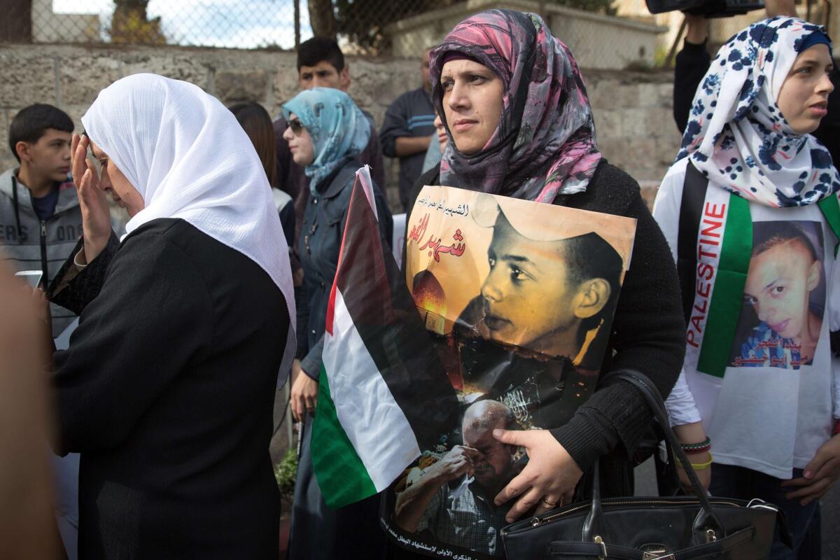 Suha Abu Khdeir, left, the mother of slain Palestinian teenager Mohammed Abu Khdeir, stands with protesters outside the district court in Jerusalem.