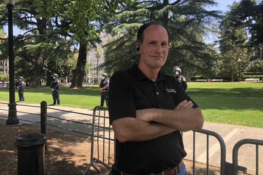 Jim Edmonds runs a bouncey house rental company near Sacramento. The shutdown has driven him close to bankruptcy, pushing him to join rallies at the state capitol. He was arrested at one on May 1, but returned for days later for another. He is pictured here standing at the Capitol, where CHP officers formed a line to keep protesters out.