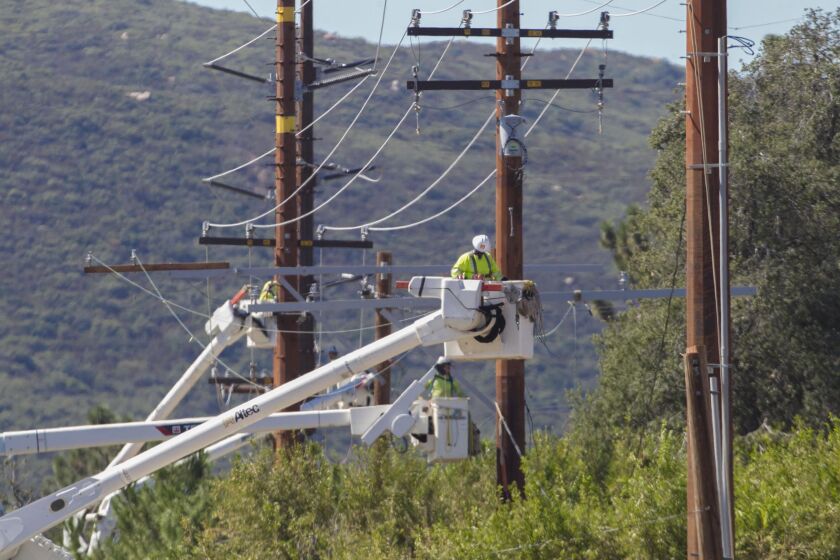 Utility construction crews work to replace wooden power poles with a system of fireproof steel structures on Viejas Blvd between Hwy 79 and Descanso on Wednesday, October 9, 2019.