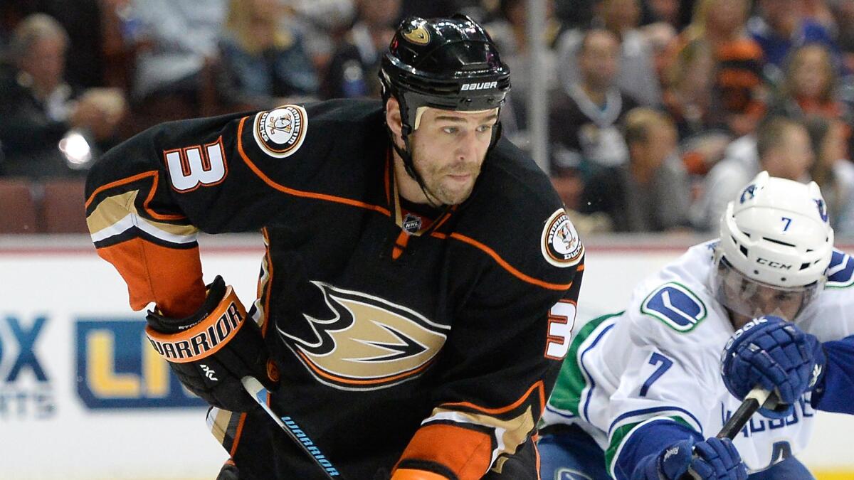 Ducks defenseman Clayton Stoner, left, clears the puck in front of Vancouver Canucks forward Linden Vey during a game on Nov. 9.