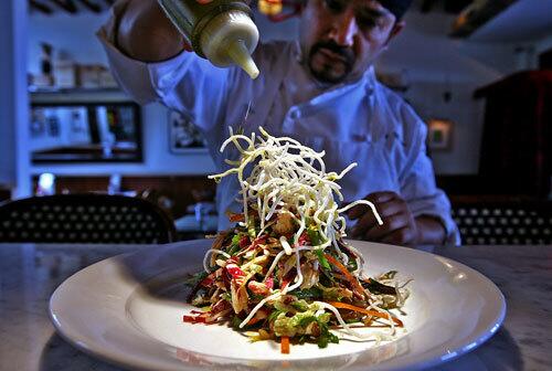 Old favorites -- prepared with flair -- are central to the menu at the new Bruce Marder restaurant House Cafe. A Chinese chicken salad gets drizzled by head chef Ricky Moreno before being delivered to the dining room.
