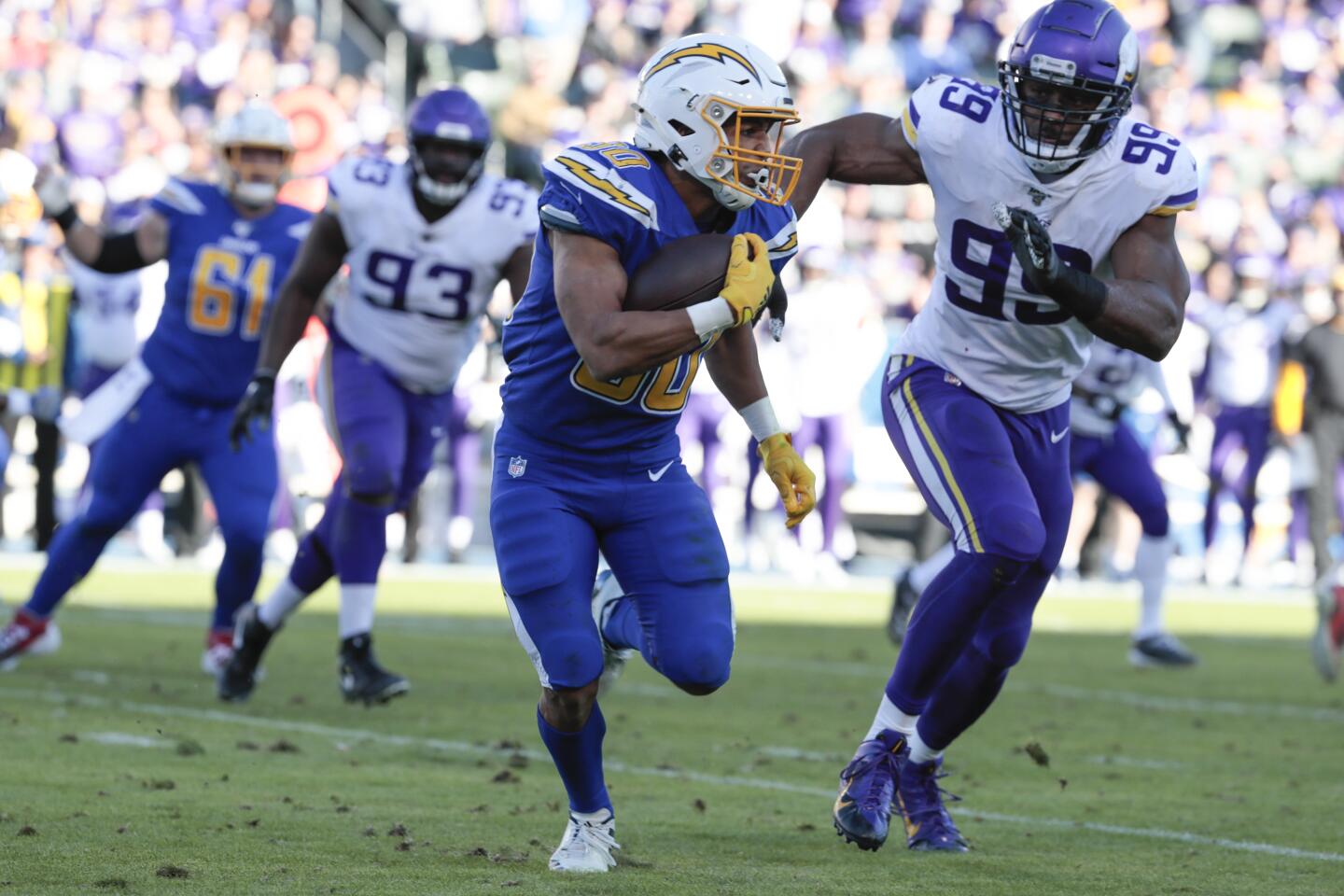Chargers running back Austin Ekeler tries to outrun Minnesota Vikings defensive end Danielle Hunter.