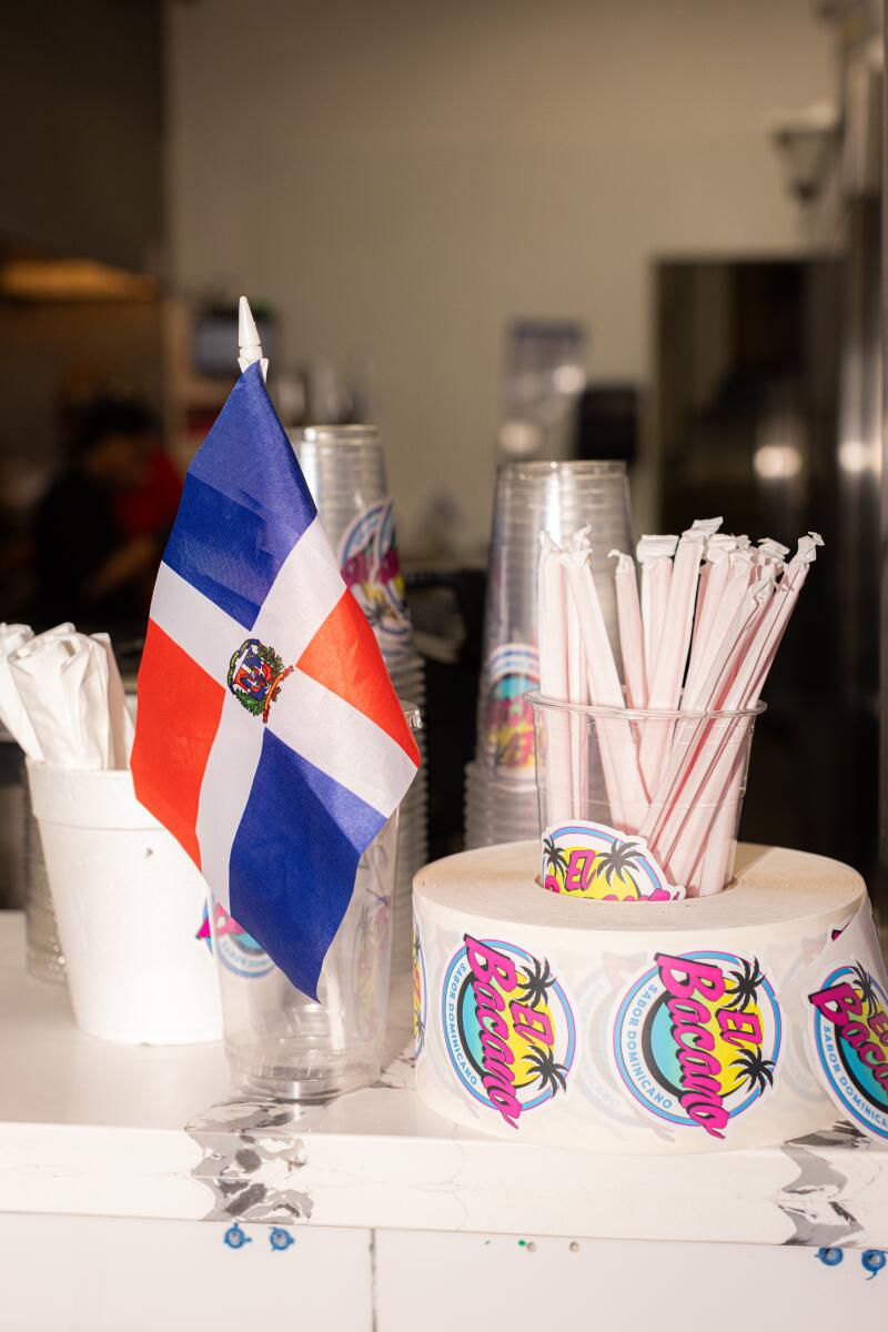 A flag from the Dominican Republic and El Bacano stickers adorn the ordering counter. 