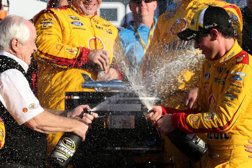 Joey Logano, right, celebrates with team owner Roger Penske after winning the Daytona 500 on Feb. 22, 2015.