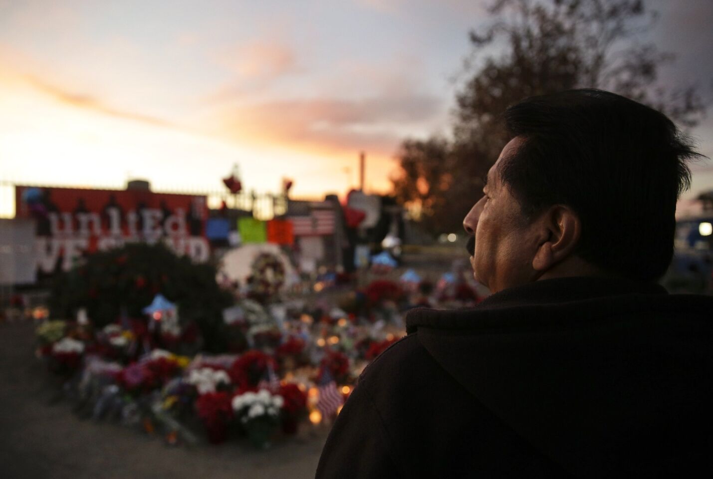 John Ramos of Riverside pays his respects Monday at a makeshift memorial site honoring Wednesday's shooting victims in San Bernardino.