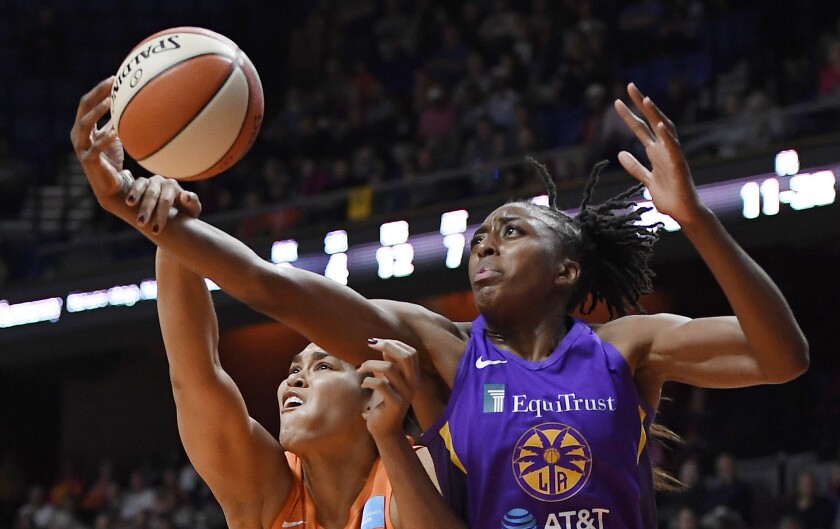 Connecticut’s Brionna Jones, left, and Sparks forward Nneka Ogwumike reach for the ball.