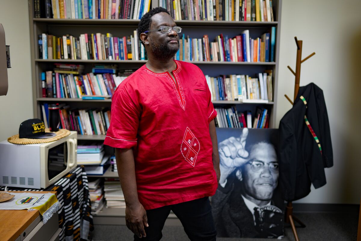 Adisa Alkebulan at his office at San Diego State University, with a photo of Malcolm X in the background