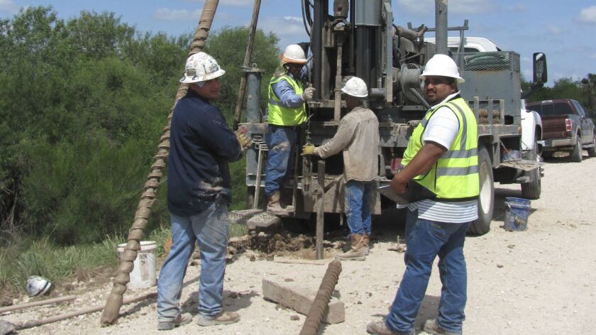 A crew uses a drilling rig to extract soil samples in the Santa Ana National Wildlife Refuge in Texas.
