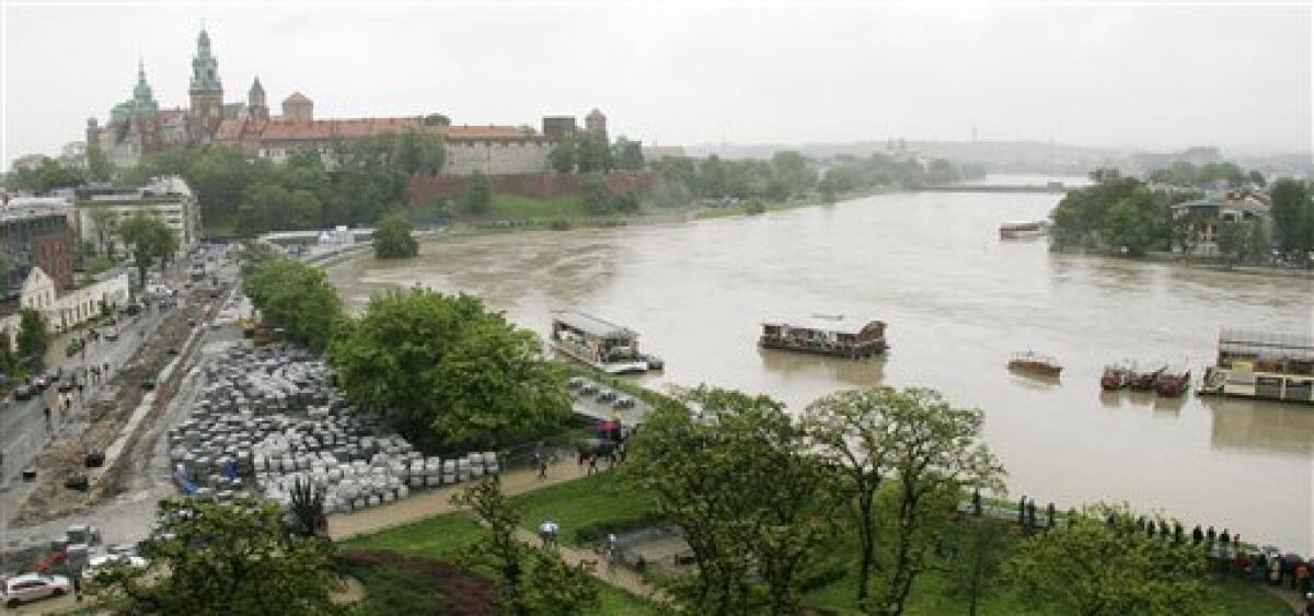 People stand on the embankment of the flooded river Wisla in the city of Krakow in Southern Poland,on Tuesday, May 18, 2010. Five persons have drowned and over 2000 have been evacuated as weather forecasts predict more rain in the coming days. (AP Photo/str)