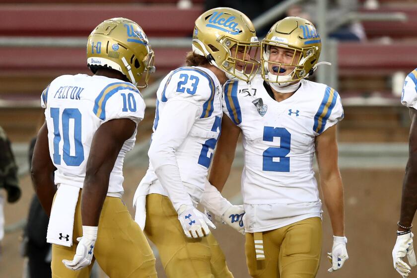 PALO ALTO, CALIFORNIA - OCTOBER 17: Kyle Philips #2 of the UCLA Bruins is congratulated by Chase Cota #23 and Demetric Felton #10 after he scored a touchdown against the Stanford Cardinal at Stanford Stadium on October 17, 2019 in Palo Alto, California. (Photo by Ezra Shaw/Getty Images) ** OUTS - ELSENT, FPG, CM - OUTS * NM, PH, VA if sourced by CT, LA or MoD **