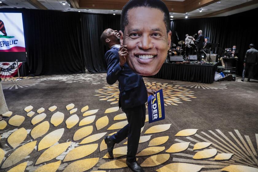 Costa Mesa, CA, Tuesday, September 14, 2021 - Errol Webber of Costa Mesa parades a cutout picture of Larry Elder at the candidates' election party at the Orange County Hilton. (Robert Gauthier/Los Angeles Times)