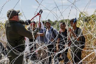 Eagle Pass, Texas, Sunday, September 24, 2023 - A border patrol agent cuts razor wire to allow migrants who've been waiting in the sun for hours, to come to a way station under the Camino Real International Bridge. (Robert Gauthier/Los Angeles Times)