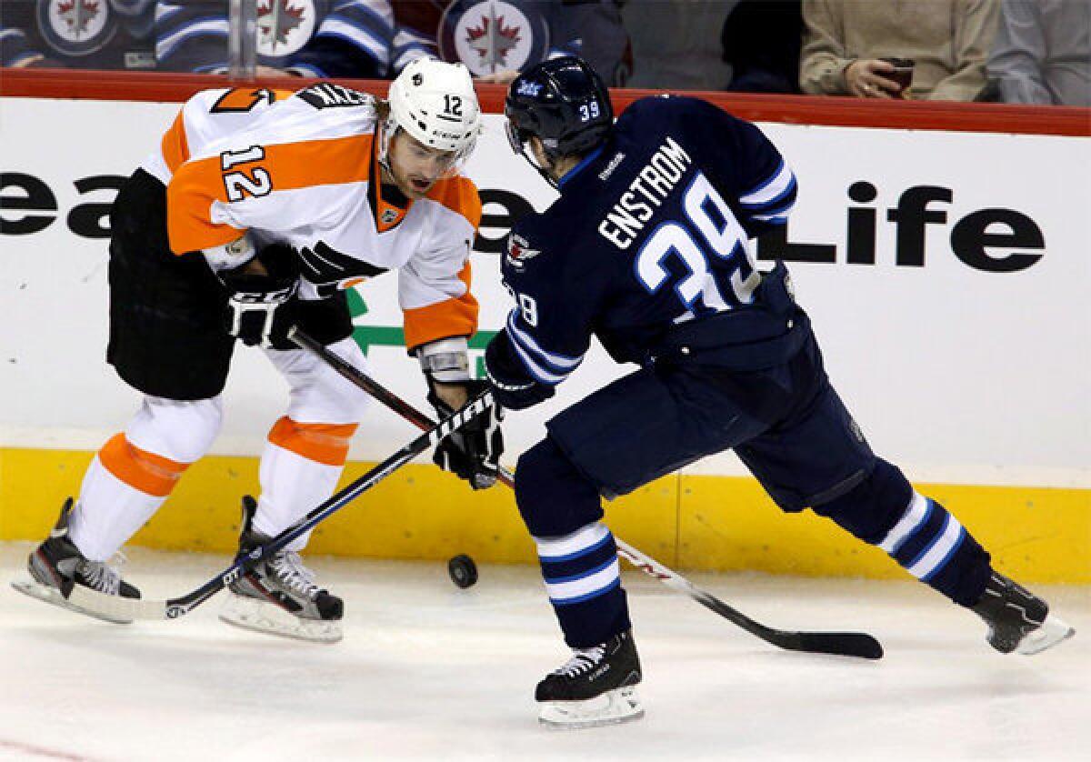 Harry Zolnierczyk (12) and Winnipeg Jets' Tobias Enstrom (39) battle for control of the puck.