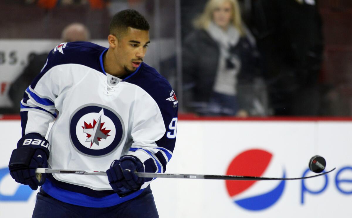 Jets forward Evander Kane hits a puck with his stick in warmups prior to a January game.