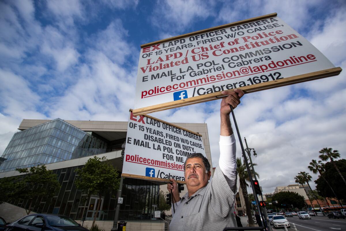 A man hold two signs in front of a building