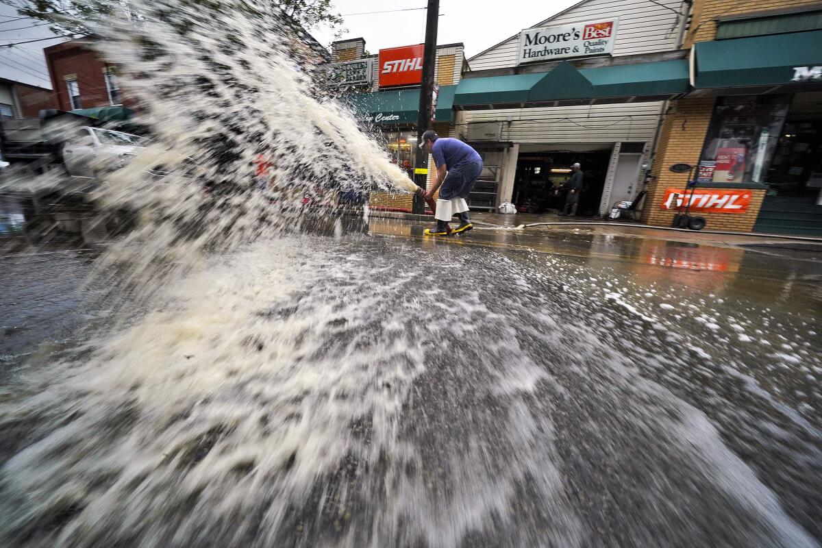 Water spews from a hose at high velocity in a city street.