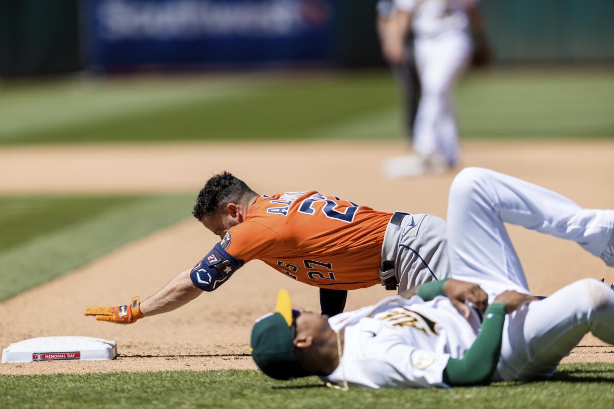 El venezolano José Altuve, de los Astros de Houston, al centro arriba,