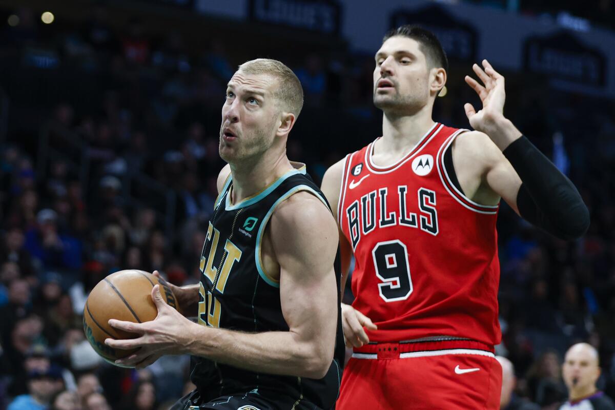 Charlotte Hornets center Mason Plumlee, left, drives to the basket in front of Chicago Bulls center Nikola Vucevic.