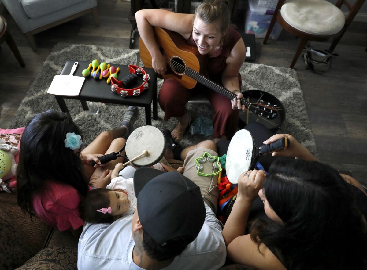 Music therapist Lindsay Zehren, top, does music therapy with the Zaragoza family of Chula Vista. They are, from left: Ava, Ari, Danny and Bianca.