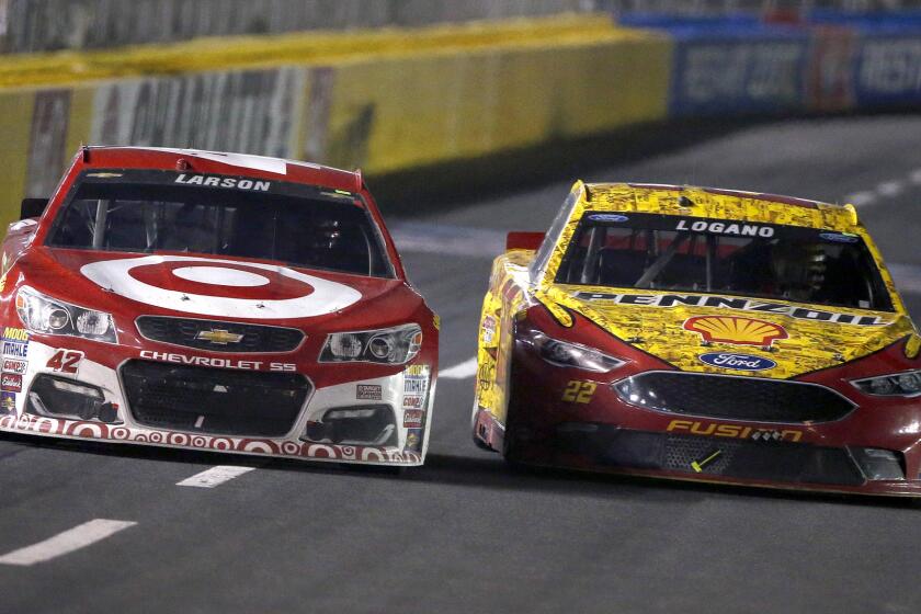 NASCAR driver Kyle Larson tries to get his No. 42 Target Chevrolet past Joey Logano in the No. 22 Shell Pennzoil Ford near the end of the Sprint Cup Series race Saturday night at Charlotte Motor Speedway.