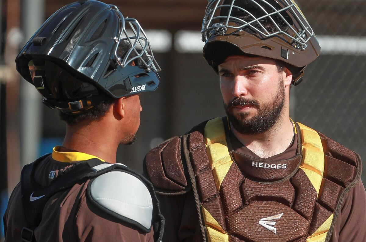Padres catchers Austin Hedges, right, and Francisco Mejia talk during spring training.