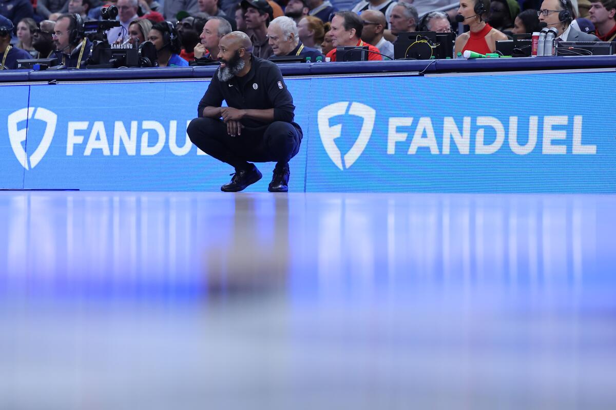 Head coach Jacque Vaughn of the Brooklyn Nets reacts near a FanDuel advertisement.