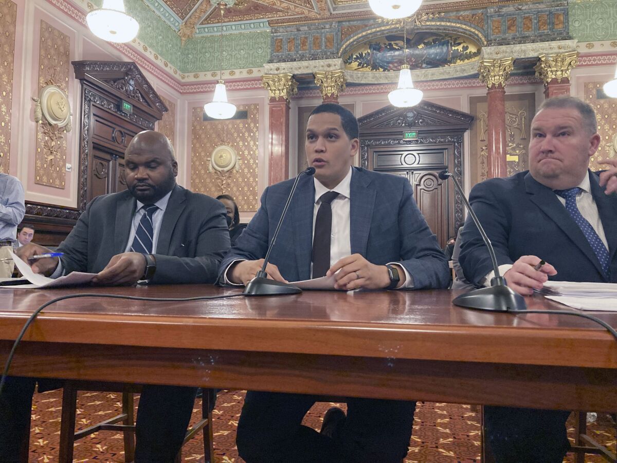 State Sen. Robert Peters, D-Chicago, center, testifies before the Senate Executive Committee on Thursday, Dec. 1, 2022, on his legislation to clarify the SAFE-T Act, a sweeping criminal justice overhaul that notably eliminates cash bail. Accompanying Peters are co-sponsors Sen. Elgie Sims, D-Chicago, left, and Sen. Scott Bennett, D-Champaign. The amendment to the law, which takes effect on Jan. 1, 2023, adds a number of forcible felonies to the list of crimes which qualify a defendant for pretrial detention, but Republicans still have concerns about it. (AP Photo/John O'Connor)