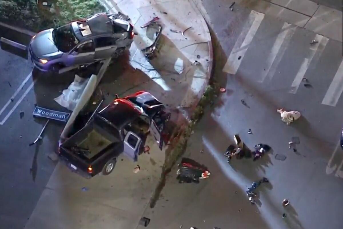 Aerial view of two car that have crashed on the corner of a street, surrounded by debris.