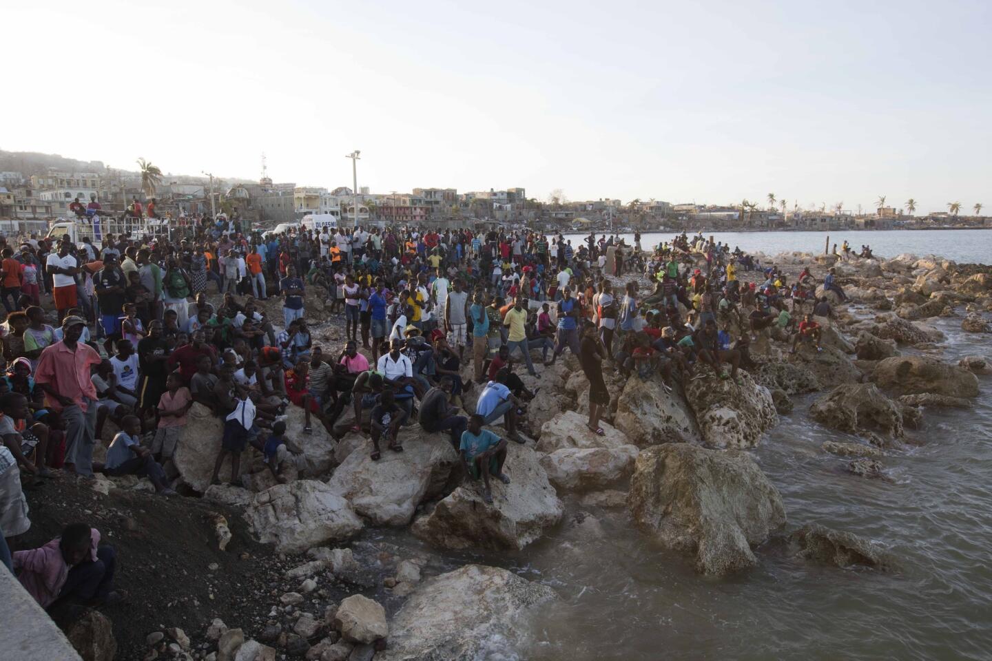 Residents wait on the shore as a boat with water and food from the "Mission of Hope" charity arrives after Hurricane Matthew swept through Jeremie, Haiti, on Oct. 8, 2016.