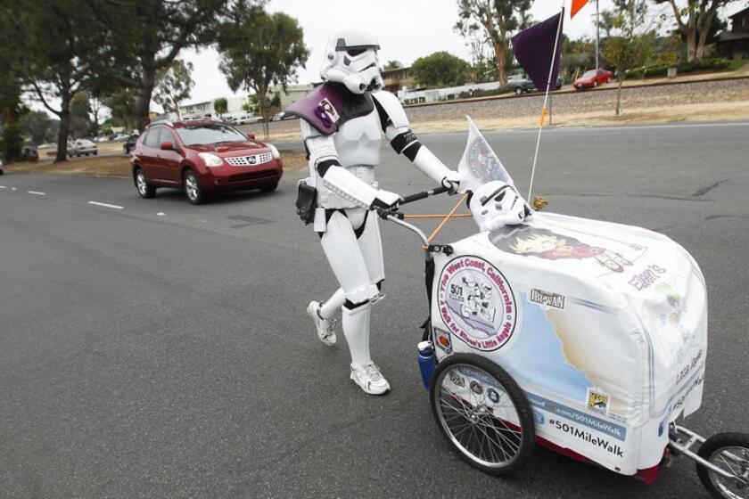 Kevin Doyle of Minnesota walks through Leucadia on Tuesday. He has spent the past month walking more than 600 miles down the California coast in his “Star Wars” Stormtrooper costume to Comic-Con in San Diego.