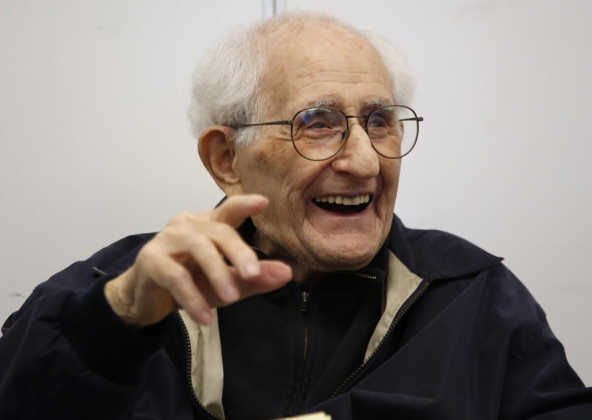 Mel Feuer, a retired teacher and principal, and a survivor of WWII and Stalag 17, laughs with students during a weekly visit to a fifth grade classroom at Castle Heights Elementary School. He died at 92 on Monday.