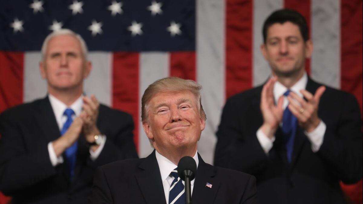 Vice President Mike Pence, left, and Speaker of the House Paul Ryan, right, applaud as President Trump delivers his first address to a joint session of Congress last February. On Tuesday night, he will give his first official State of the Union speech.