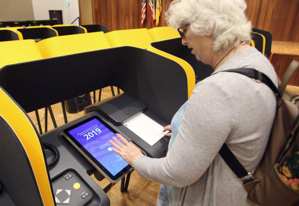 Glendale resident Mary Mullen uses a touch screen to cast a mock vote at the Glendale Downtown Central Library over the weekend.