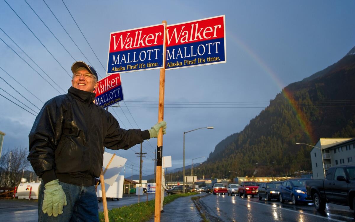 Byron Mallott, a candidate for Alaska lieutenant governor, waves a sign in Juneau on election day. Mallott's running mate is Bill Walker, who narrowly leads Gov. Sean Parnell.