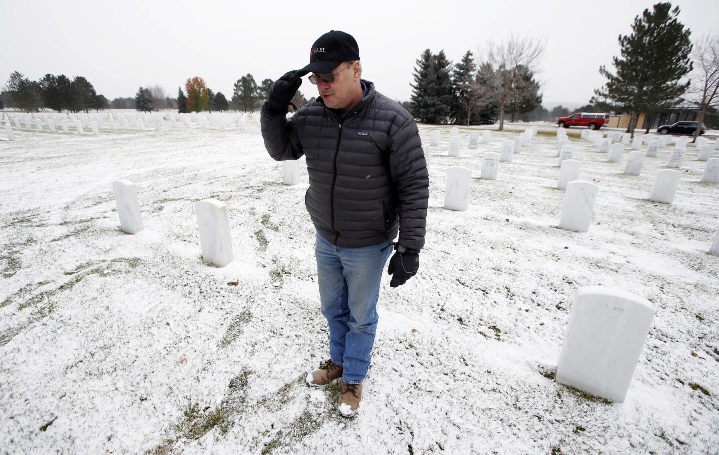 To commemorate Veterans Day, John Smigel salutes at the grave of Army Sgt. Robert W. Raiser, a World War II veteran, at Ft. Logan National Cemetery in Denver.