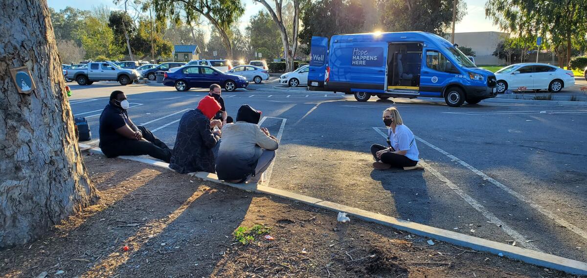 A member of Be Well OC's Mobile Crisis Response Team performs outreach to people living in Huntington Beach.