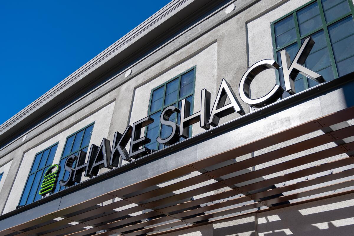 Sign on a facade reads Shake Shack in silver letters