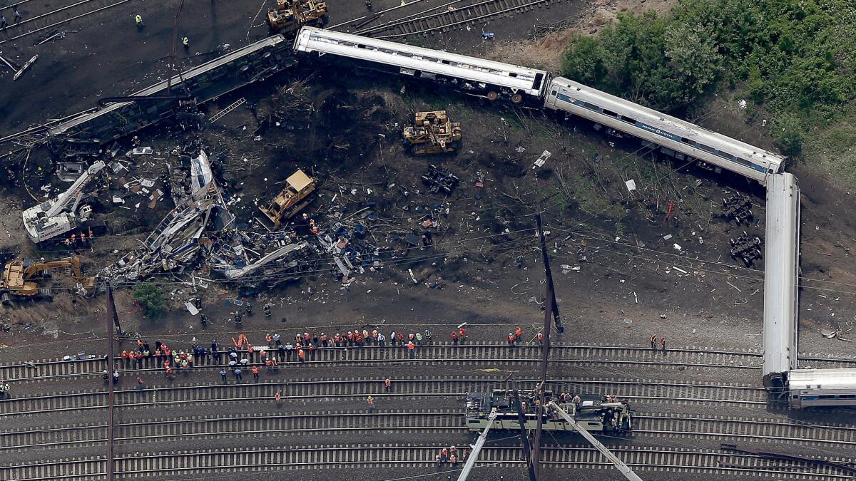 Investigators and first responders work near the wreckage of Amtrak Northeast Regional Train 188 that derailed in May in north Philadelphia.