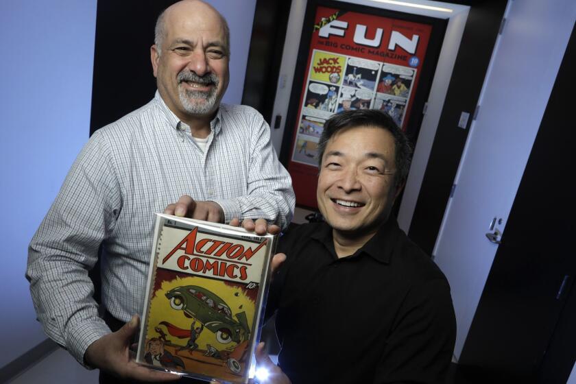 BURBANK, CALIF. -- MARCH 21, 2018: Co-publishers of DC Comics, Dan DiDio (left) and Jim Lee, holding a copy of the first Action Comics and the first to feature Superman which is kept in the company's archive. Action Comics #1000 will soon be released. (Myung J. Chun / Los Angeles Times)