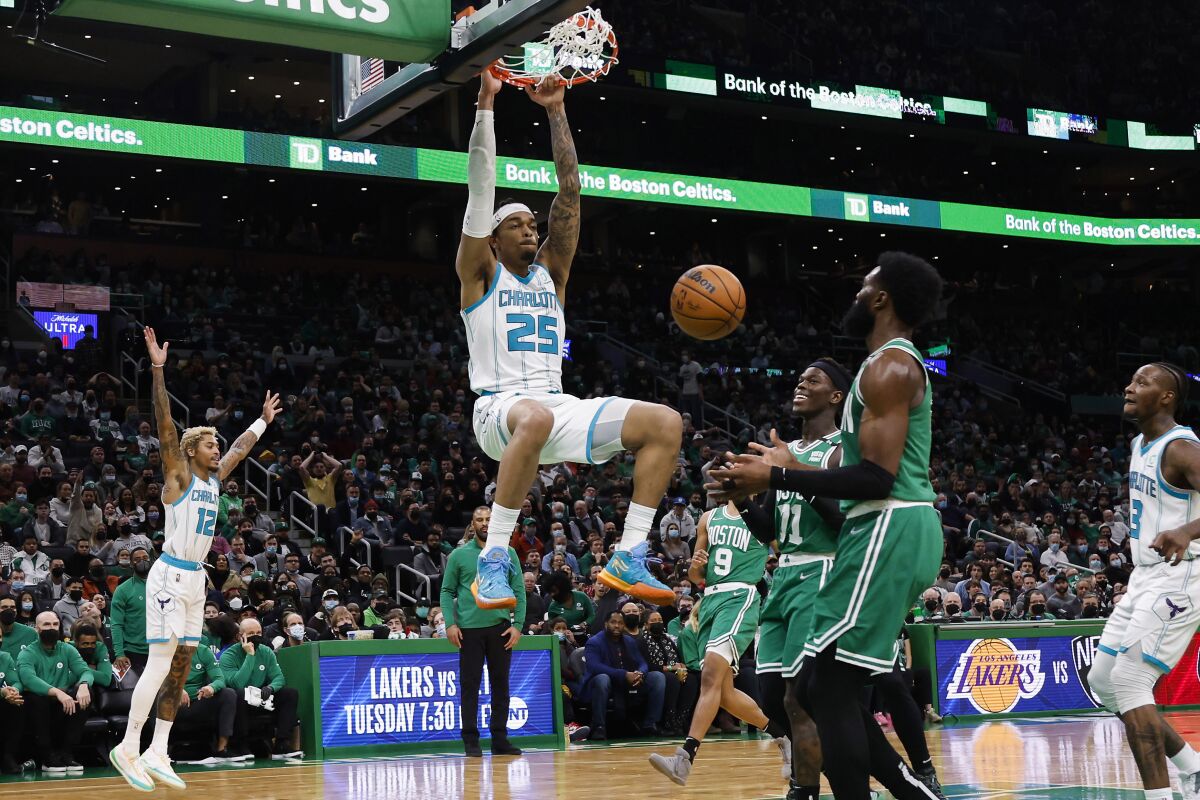 Charlotte Hornets' P.J. Washington dunks as Boston Celtics' Dennis Schroder looks on during the second half of an NBA basketball game Wednesday, Jan. 19, 2022, in Boston. (AP Photo/Winslow Townson)