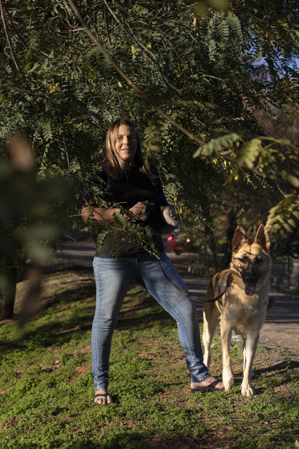 Runaway dog tracker and trapper Babs Fry stands with her dog Lady Bug at her ranch in Jamul.