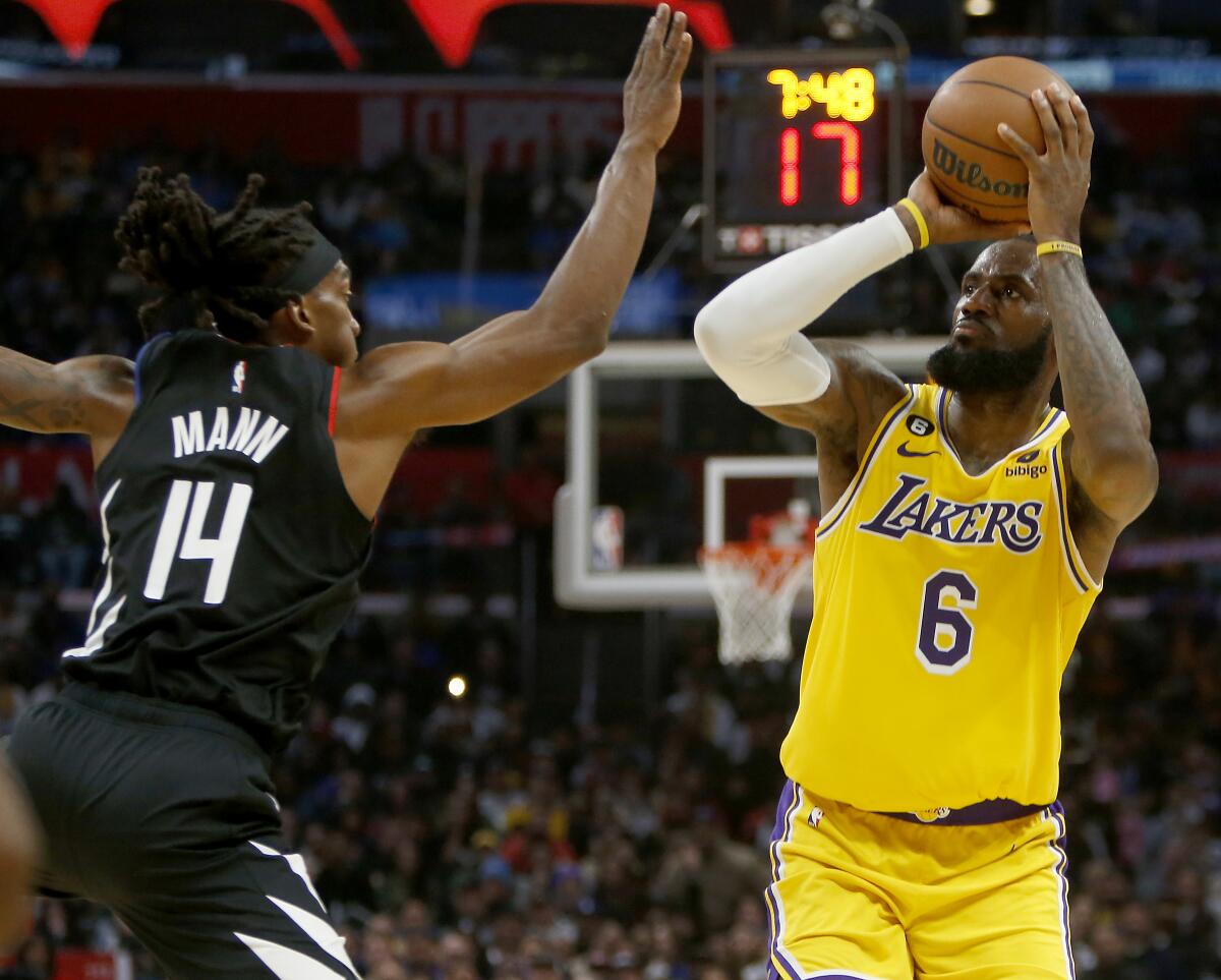 Lakers forward LeBron James elevates for a jump shot against the defense of Clippers guard Terance Mann.