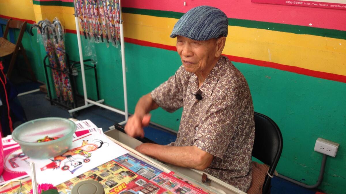 Artist Huang Yung-fu, 96, began painting the buildings and grounds of the village in 2008.